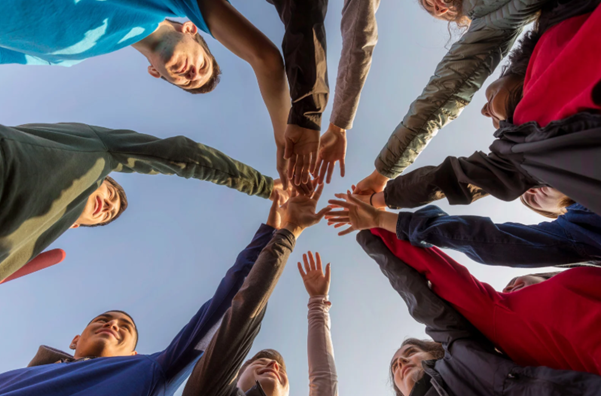 Group of people engaging in social interaction representing what is community wellbeing and the importance of connection and belonging.